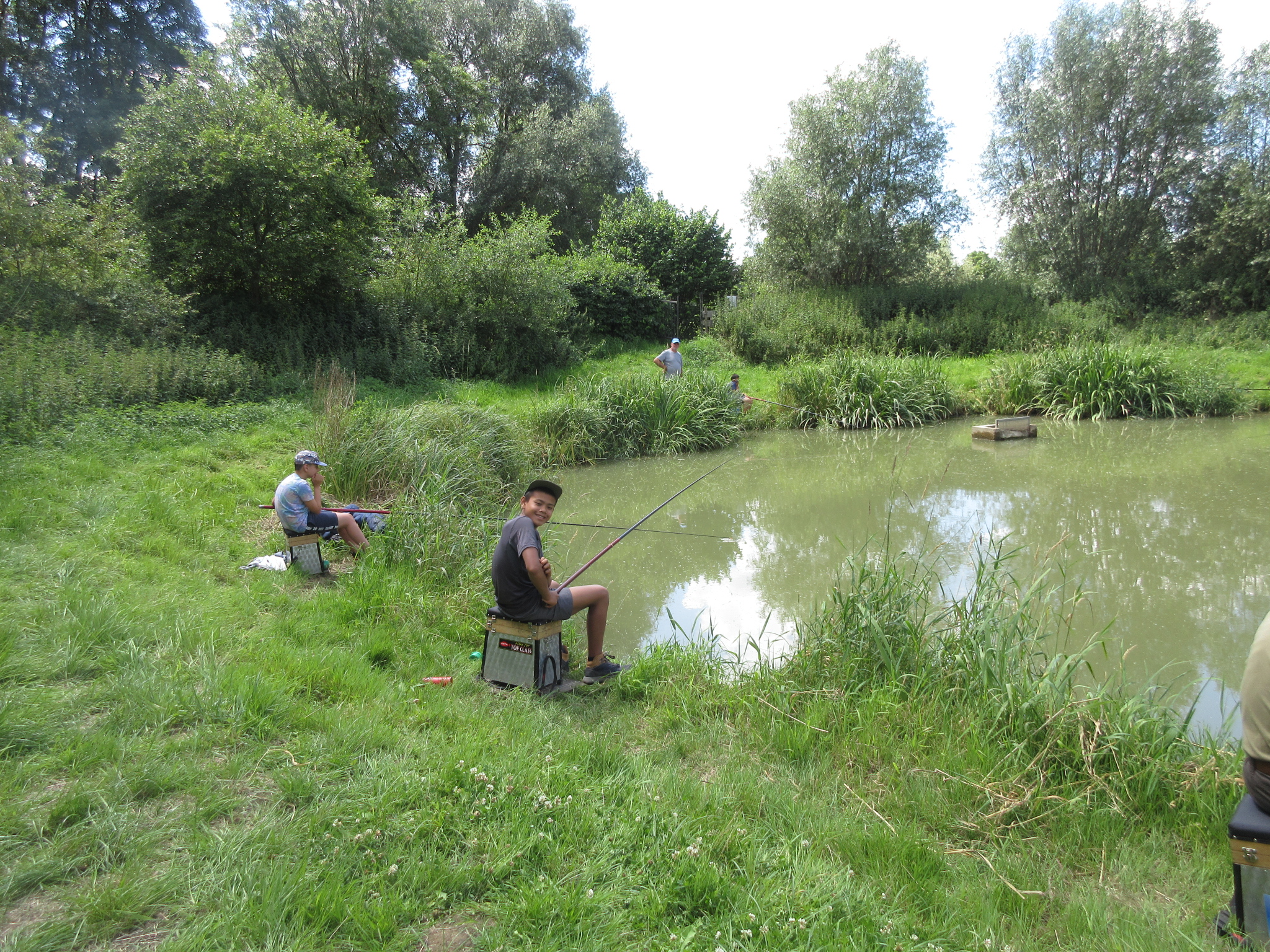Adolescents en train de pêcher au bord de l'étang du Village du Saule de Braives